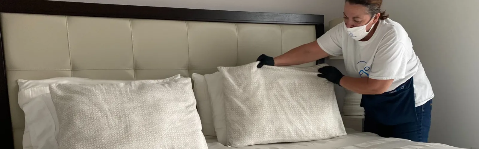 MaidPro Hudson house cleaner fluffing pillows and making a bed in Florida