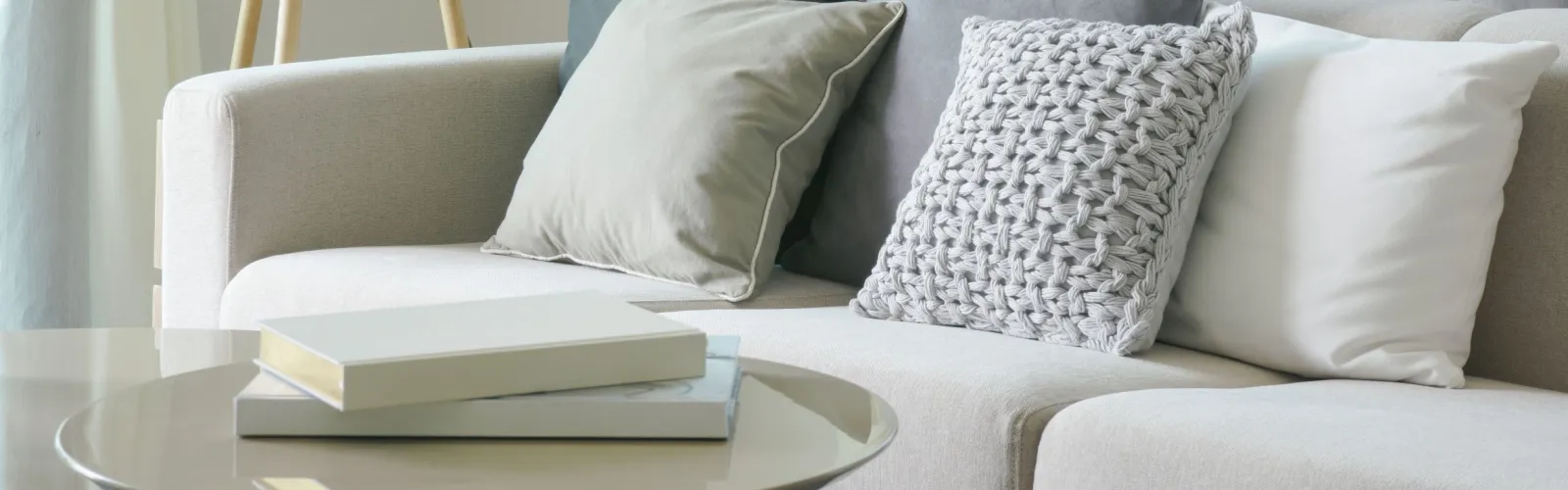 a living room with a white couch and a mirror