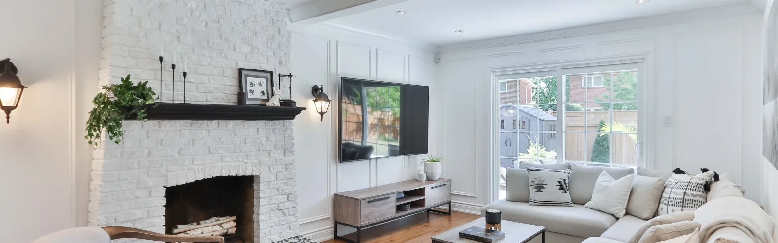 a living room with a white couch and a mirror