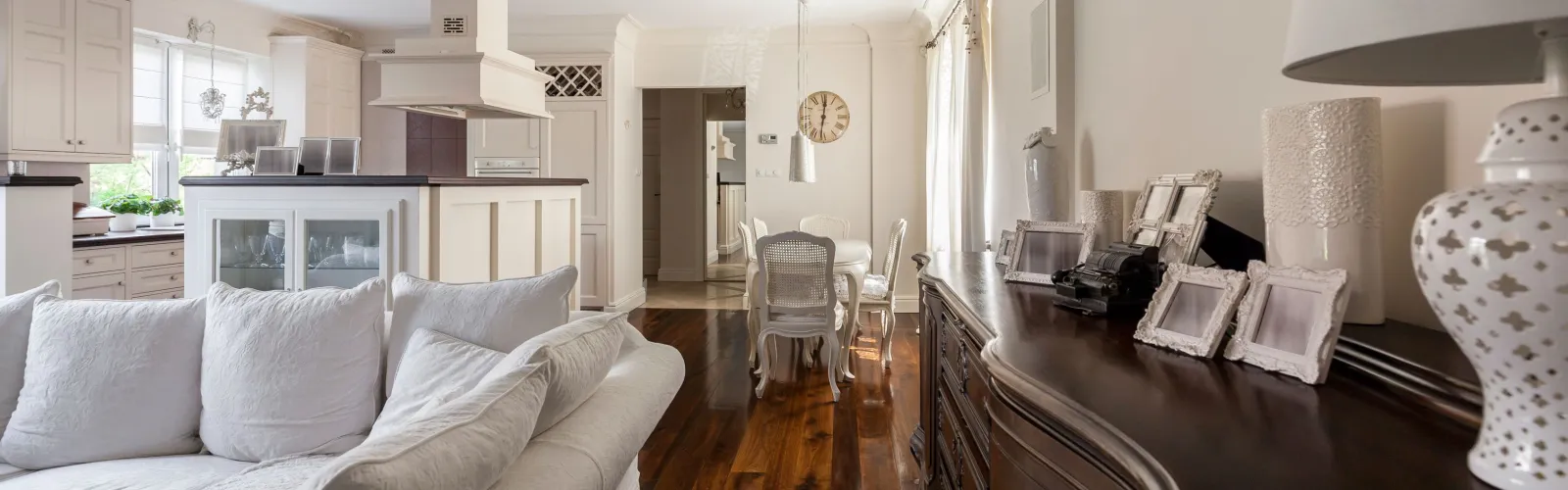 a living room with a white couch and a mirror