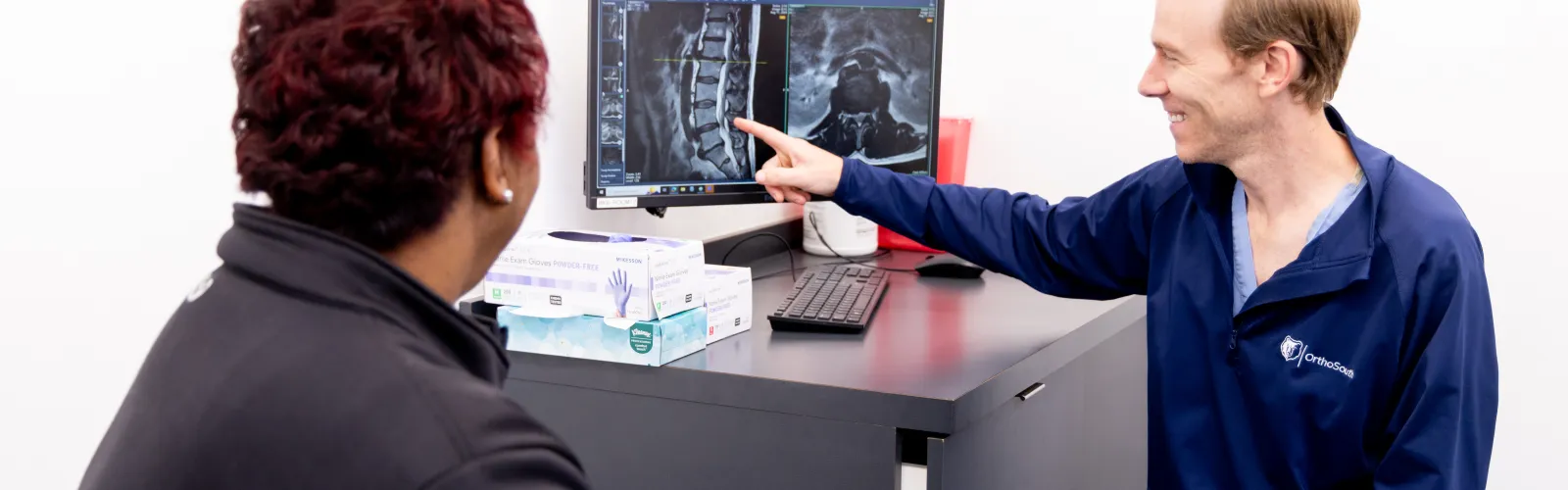a man showing a woman something on the computer