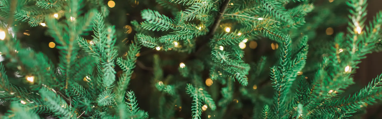 close up of an artificial christmas tree with white christmas lights