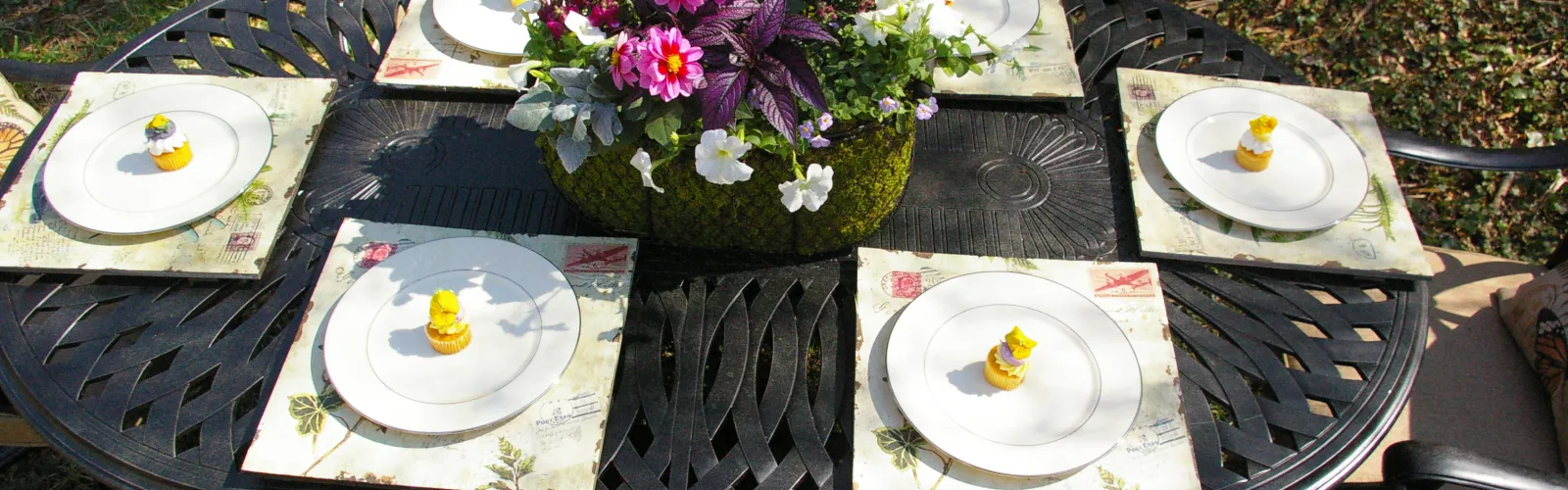 Outdoor garden party with flower centerpiece and plants with desserts
