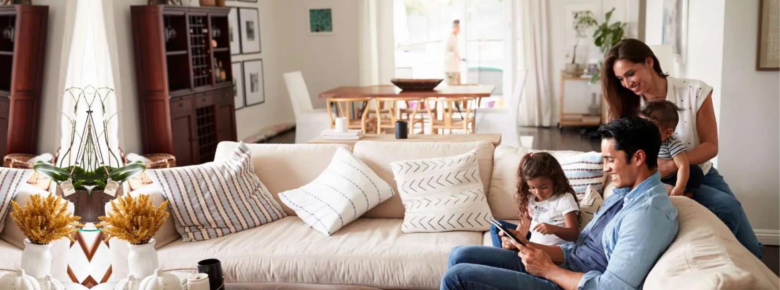 Family of four enjoying time together in a cozy, modern living room with neutral decor and natural light.