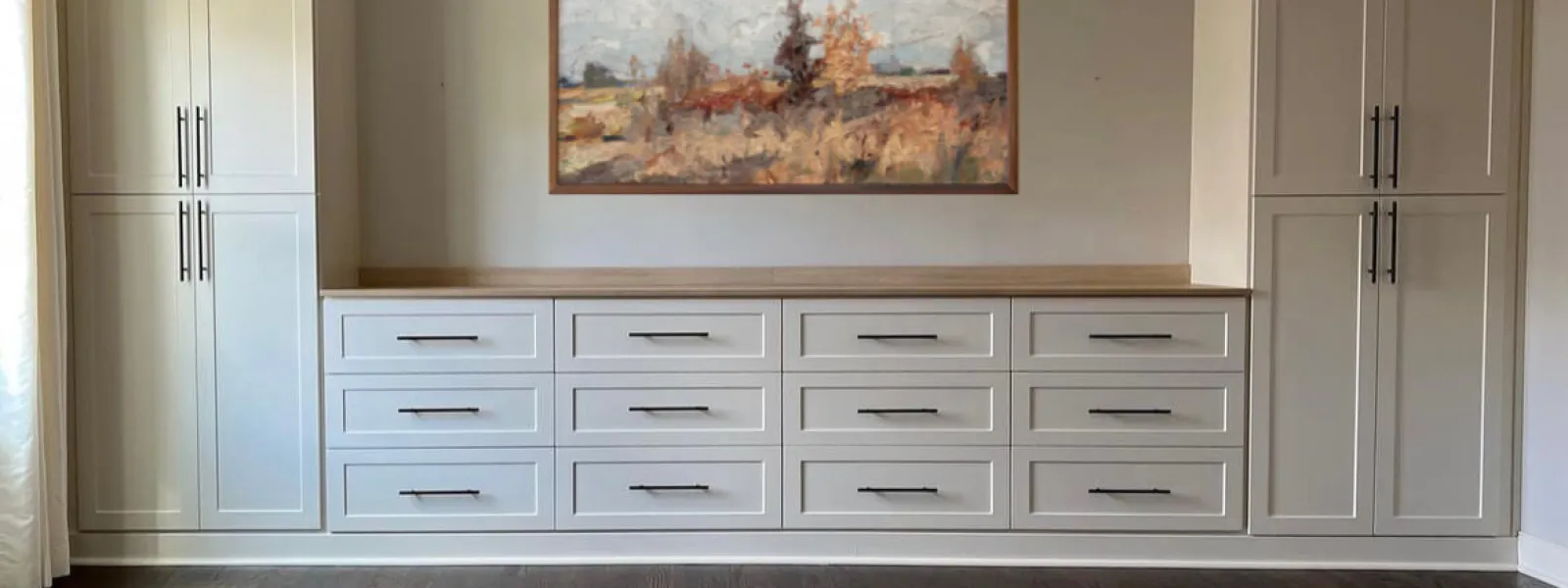 a room with white cabinets and a painting on the wall