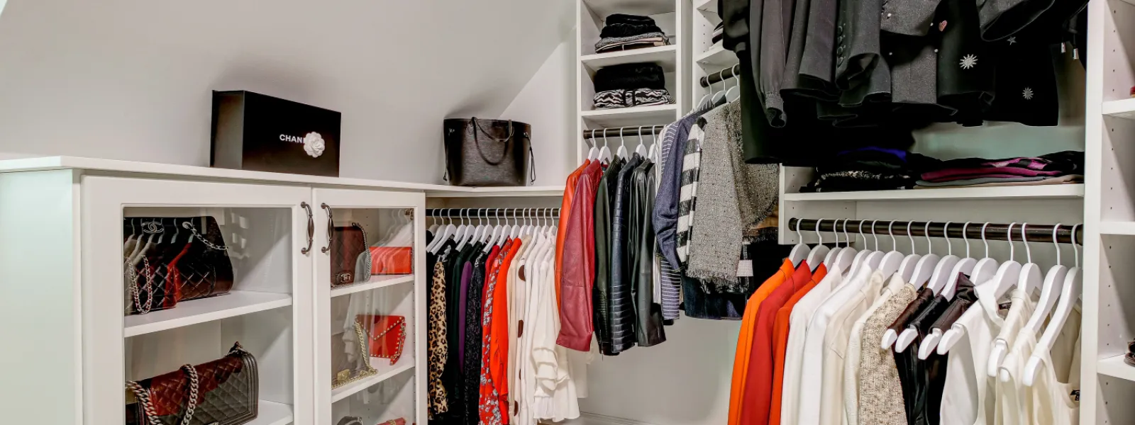 a master closet with clothing hanging on racks