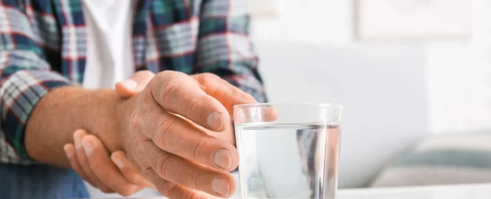 a close-up of hands holding a glass of water