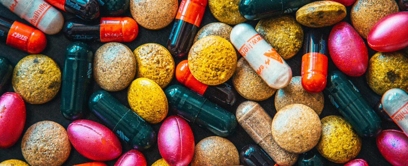 a pile of different colored pills