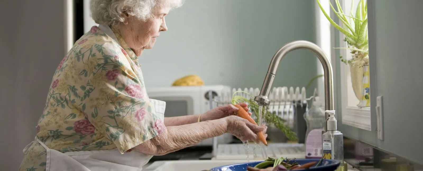 an old woman washing dishes