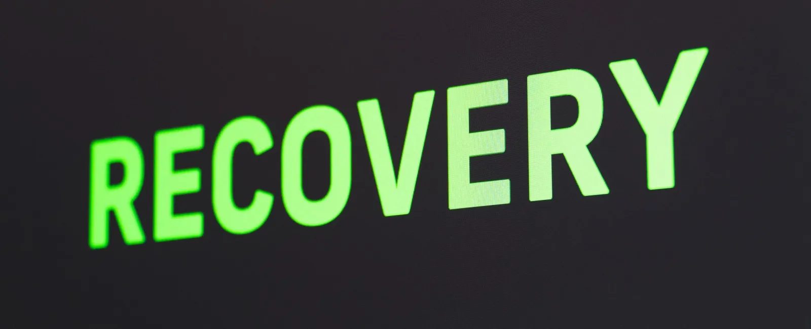 Green glowing text 'RECOVERY' on a dark background indicating data or system recovery process.
