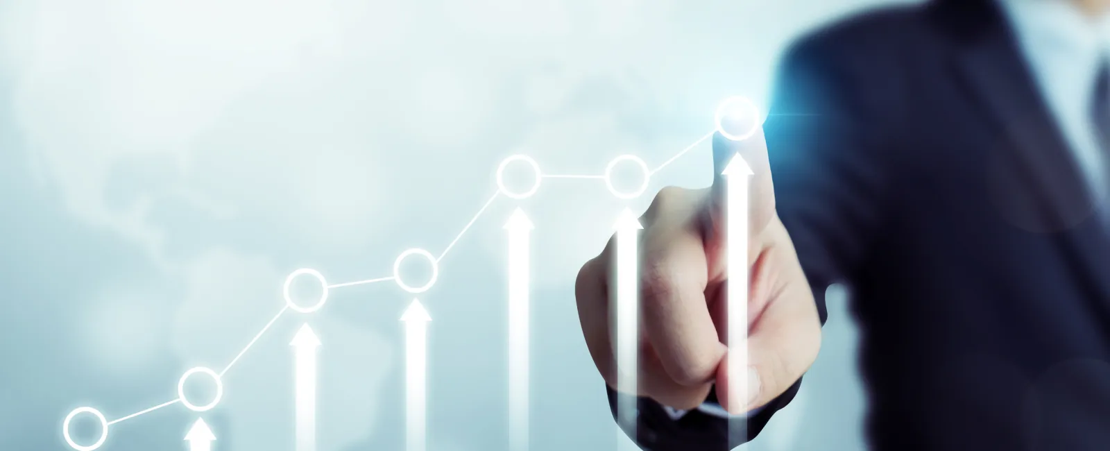 Businessman in suit pointing at rising arrow graph representing growth and success on transparent screen.