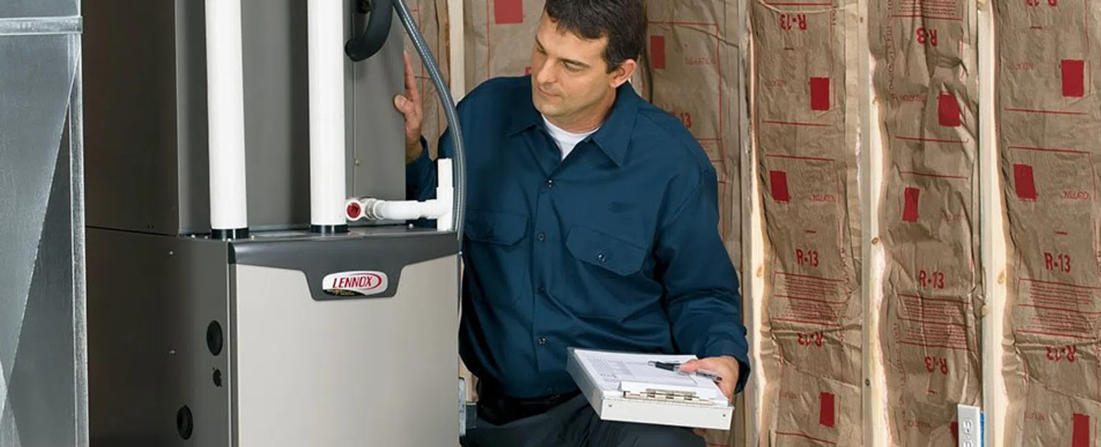 Technician inspecting a Lennox furnace in an unfinished attic with exposed insulation and ducts.