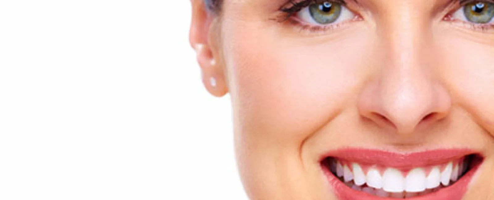 Close-up of a smiling woman with green eyes, clear skin, and white teeth on a white background