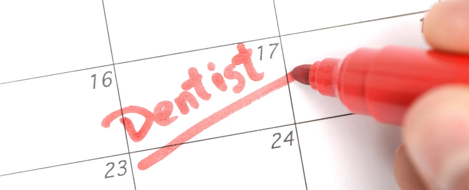 Close-up of calendar with the word Dentist written and underlined in red marker on the 17th