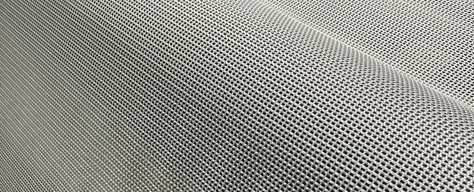 Close-up of a fine metal mesh fabric showcasing a woven grid pattern with a silver-gray finish.