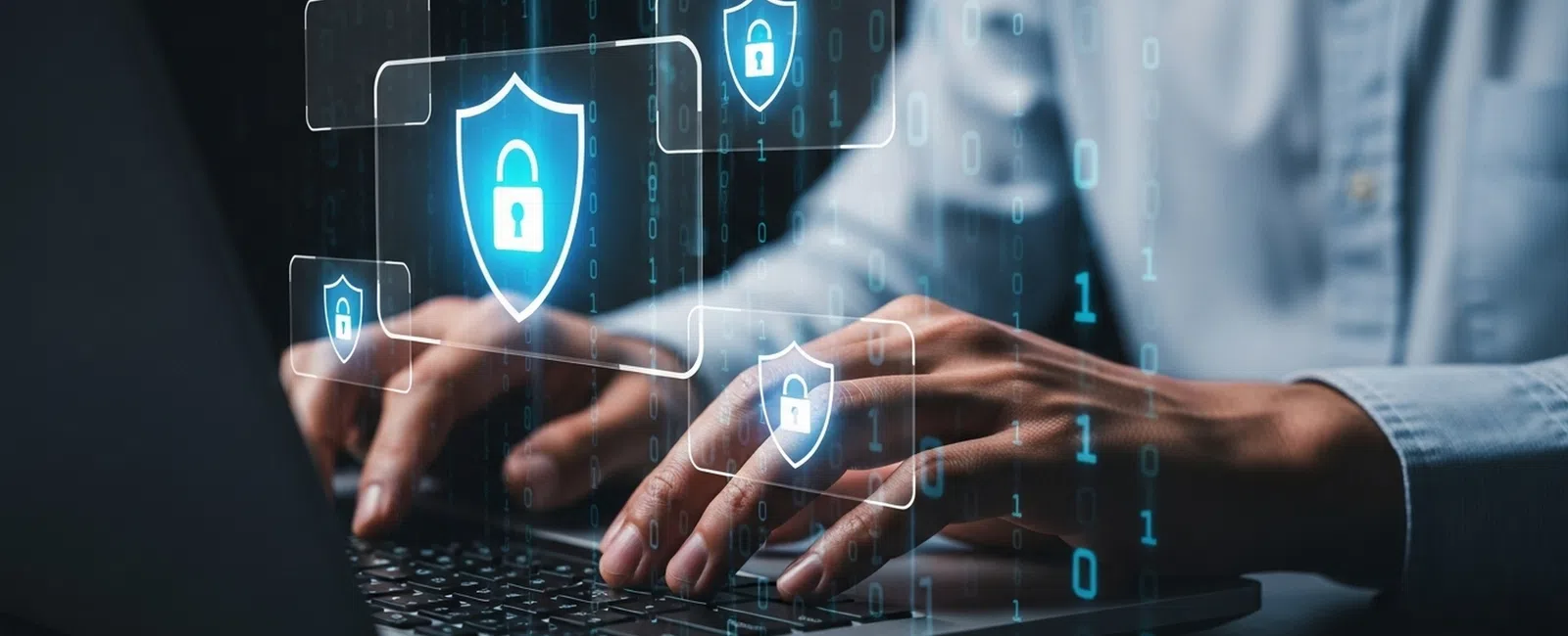Person typing on laptop with digital shield icons symbolizing cybersecurity and data protection.