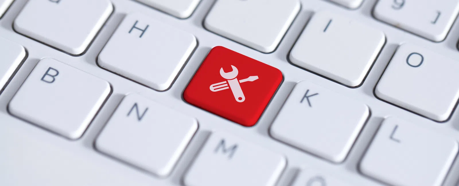 White keyboard with a red key featuring a wrench and screwdriver icon symbolizing tools or maintenance.
