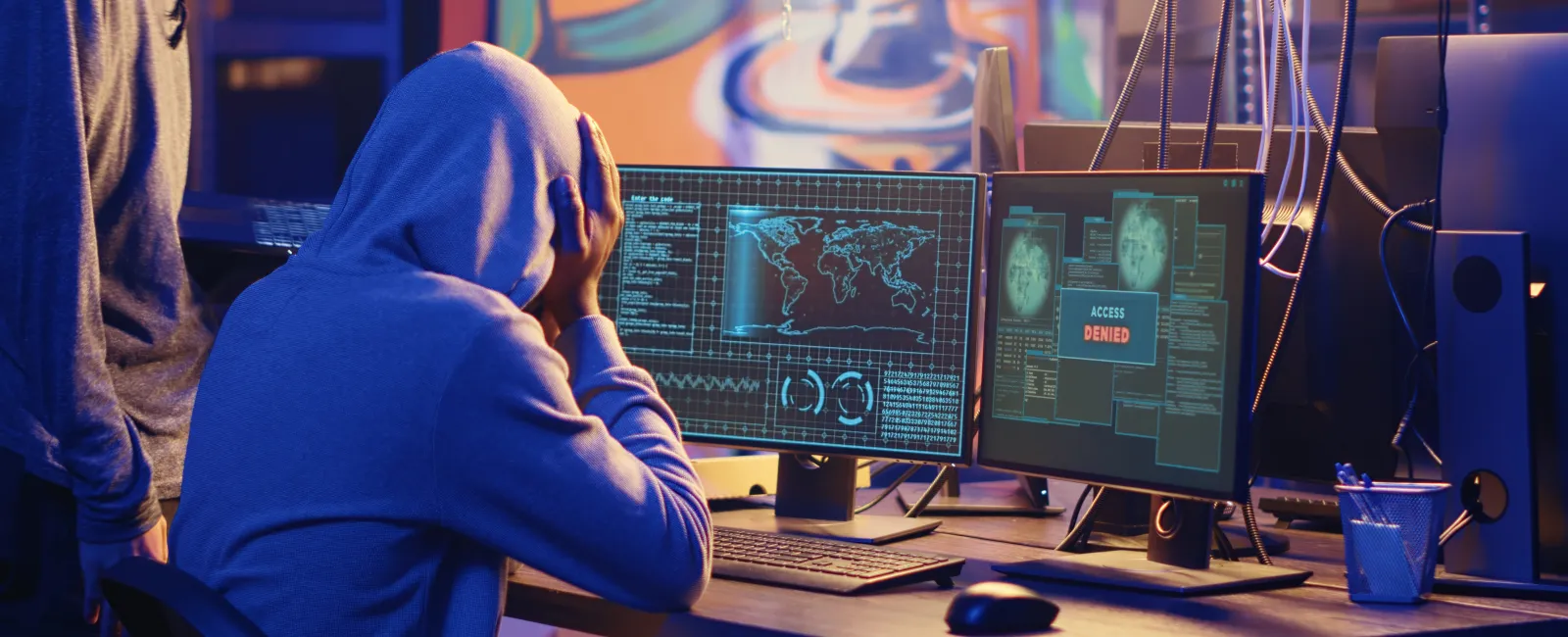 a man sitting at a desk with a computer and a monitor
