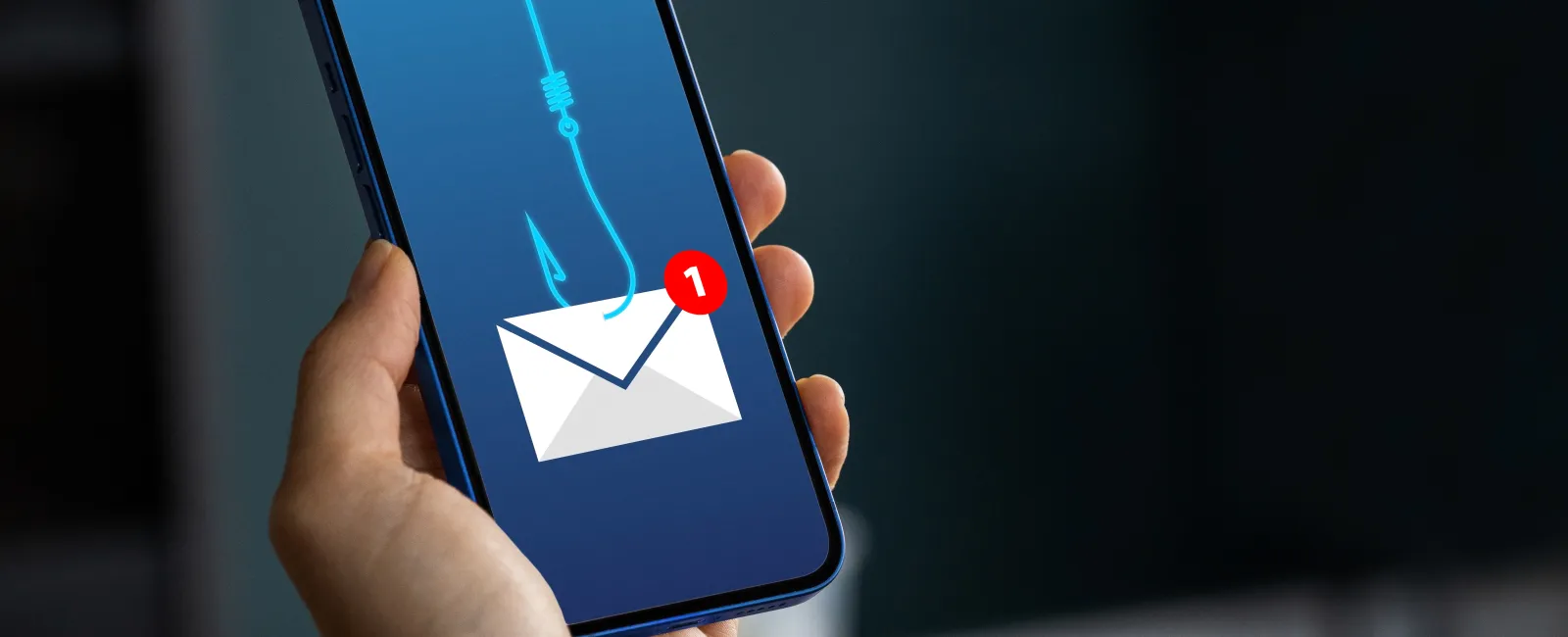 Hand holding smartphone showing phishing email alert with fishhook and envelope icon on screen