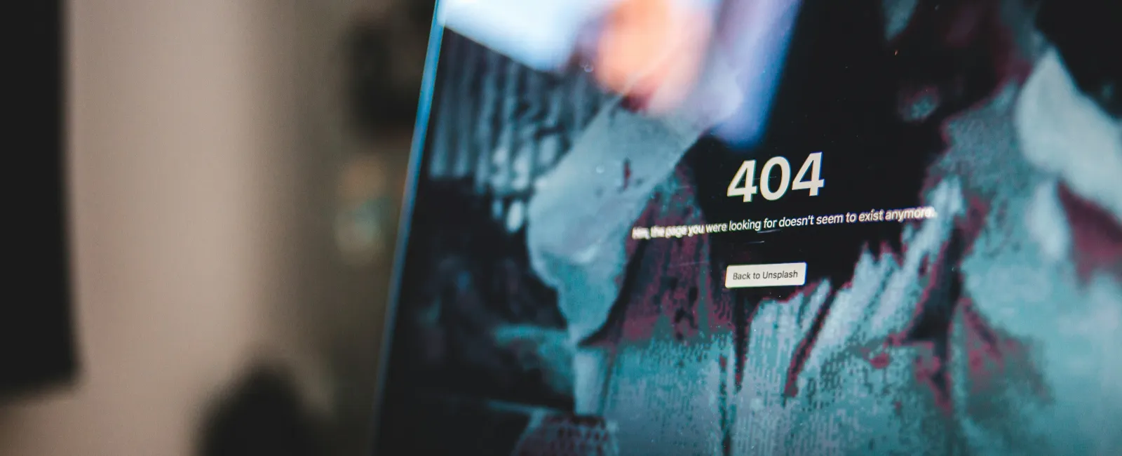 MacBook Pro screen displaying a 404 error page with a blurred background and reflections on the screen.