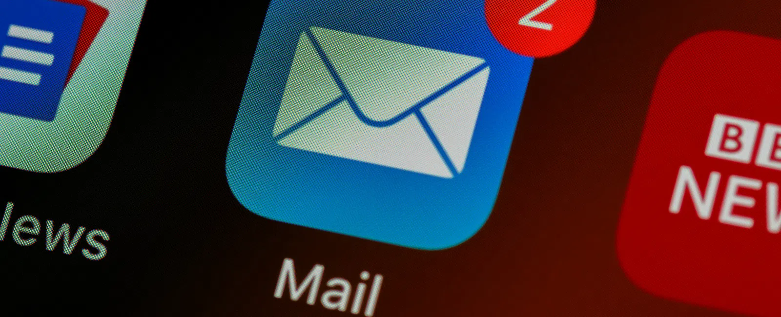 Mail app icon with two unread messages notification on a smartphone screen among other app icons.