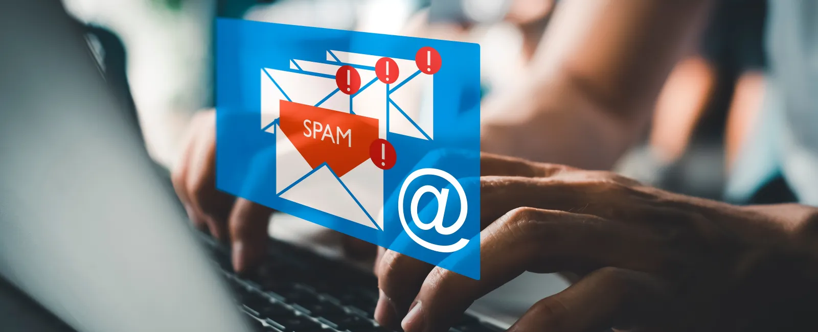 Person typing on laptop with digital spam email alerts and notification icons on screen.