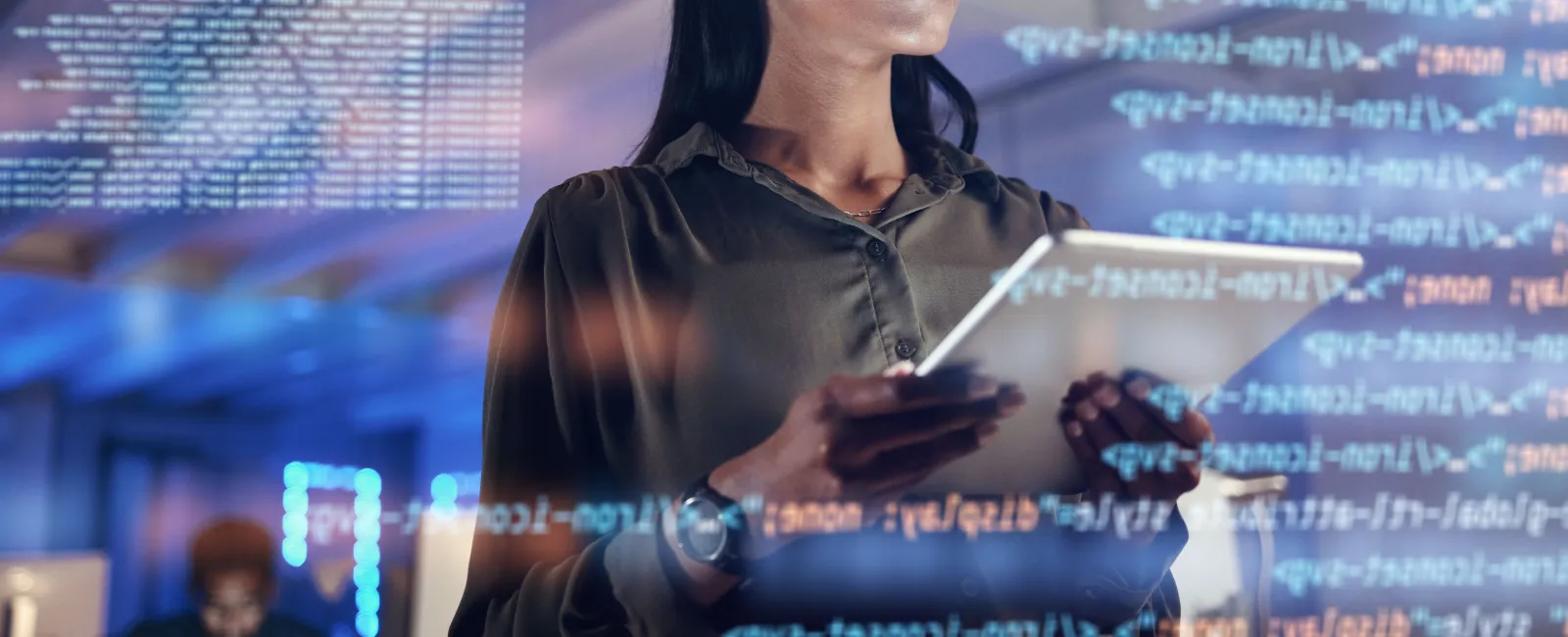 Focused woman with glasses using a tablet while digital code overlays convey programming and technology.