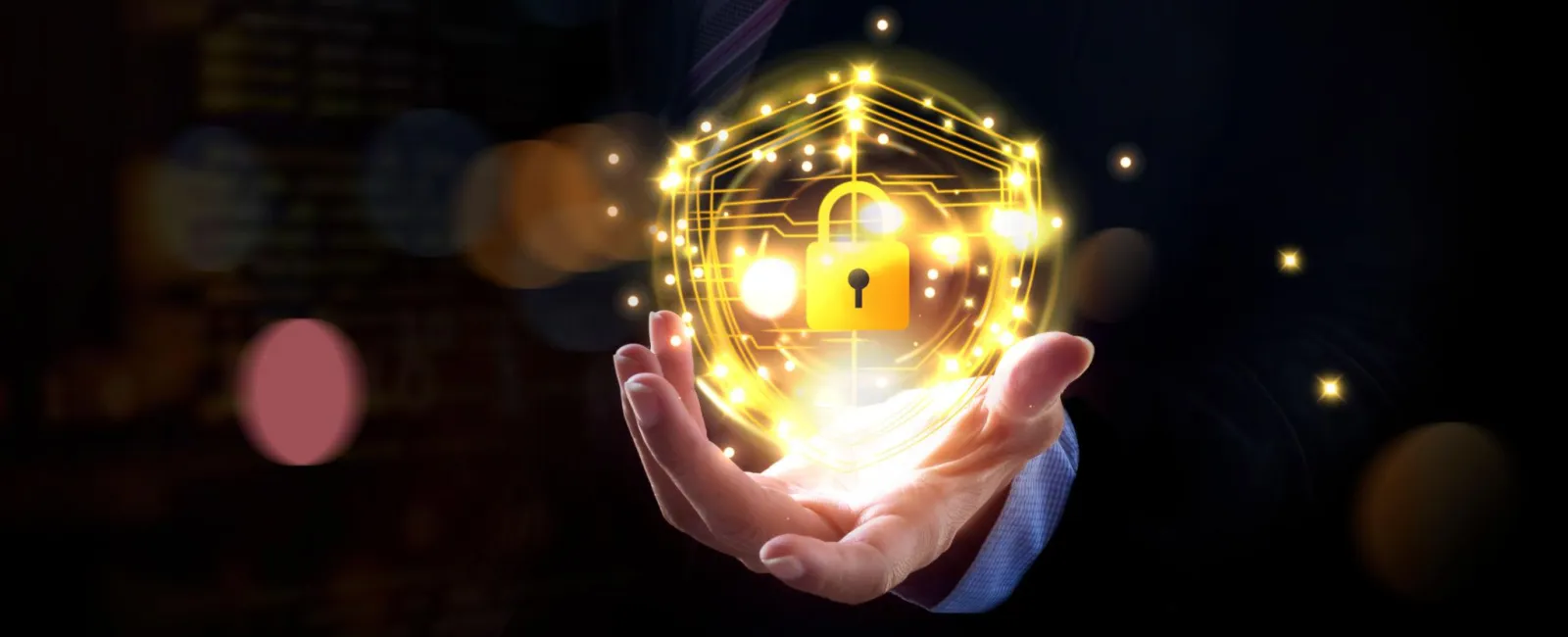 Businessman holding glowing golden padlock and shield symbolizing digital cybersecurity and data protection.