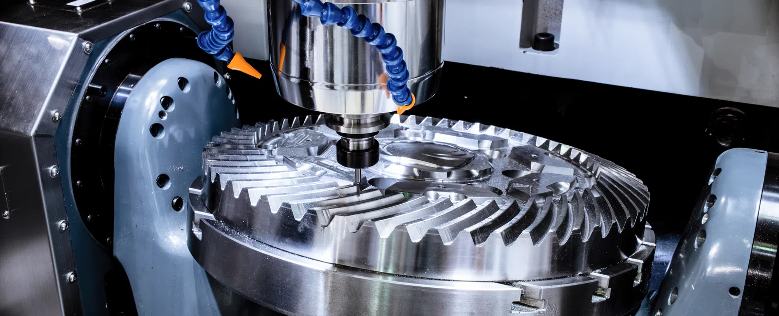 CNC milling machine machining a large metal gear with precision cutting tools and cooling system.