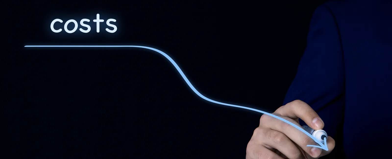 Business hand drawing a glowing line graph showing decreasing costs on black background.