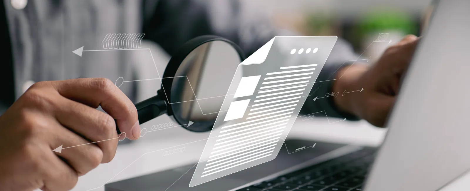 Person using magnifying glass to examine digital document on laptop, symbolizing data analysis or audit.
