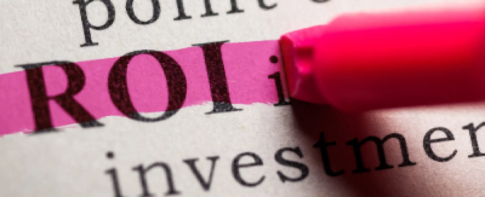 Close-up of the word ROI highlighted in pink on a printed page with a pink marker.