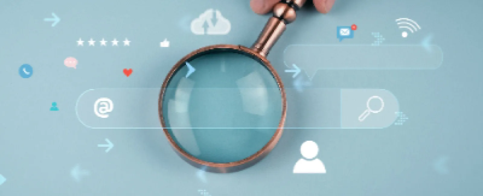 Hand holding magnifying glass over digital icons representing search, cloud, and communication on blue background