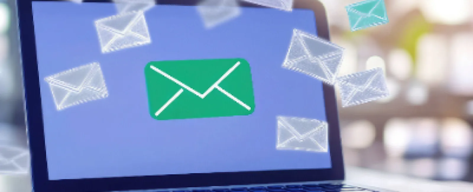 Laptop displaying email icon with multiple floating envelope icons representing digital messages.