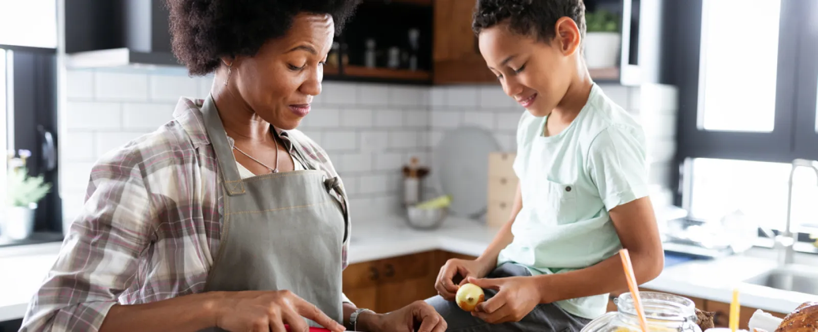 a person and a boy cutting vegetables