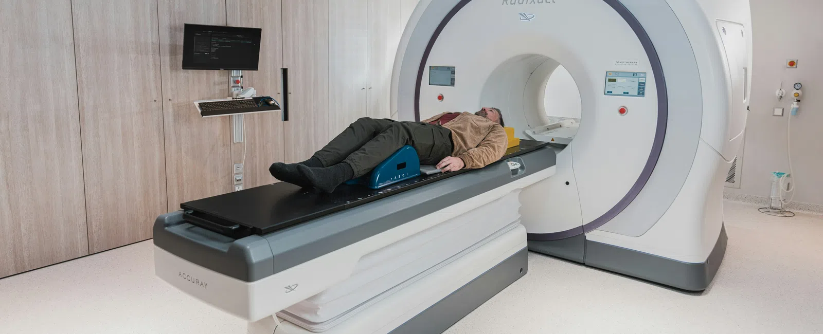 Patient lying on a table entering a Radixact radiotherapy machine in a modern clinical room.