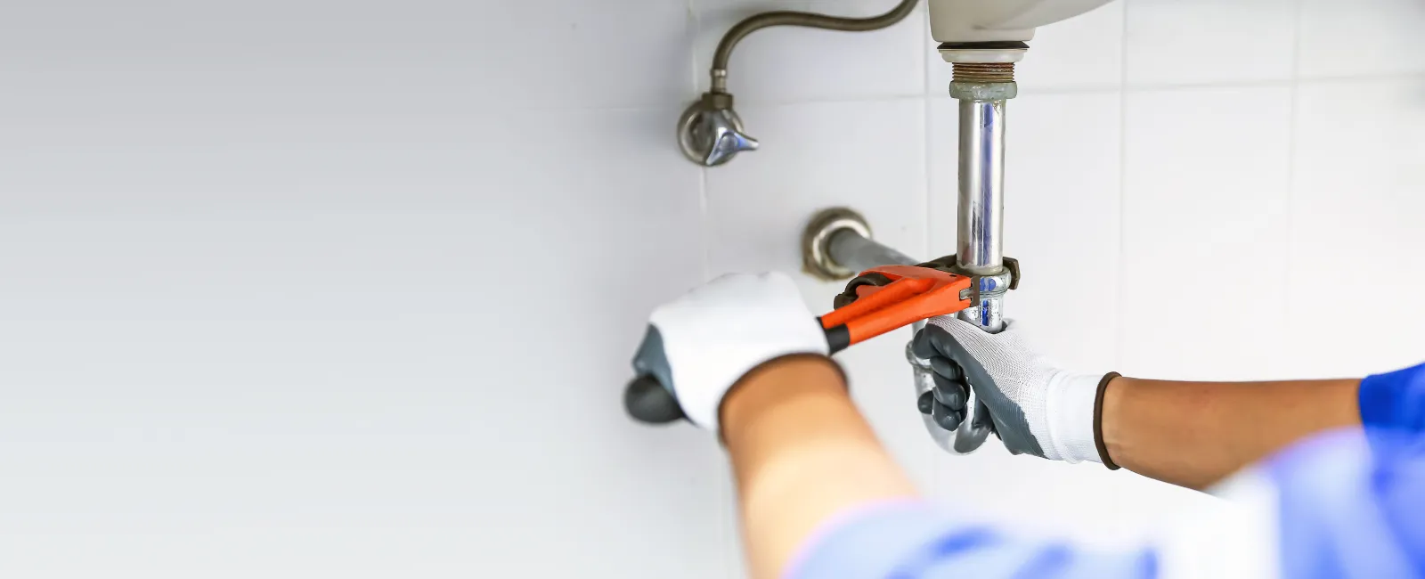 a person repairing a drain leak