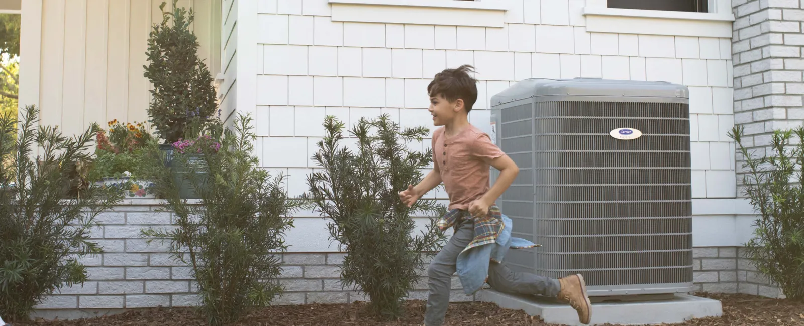 a boy running in front of a house