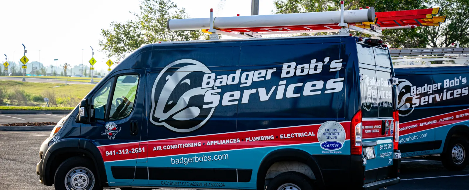 Blue Badger Bob's Services van with ladder on top parked in lot, offering plumbing, electrical, and air conditioning