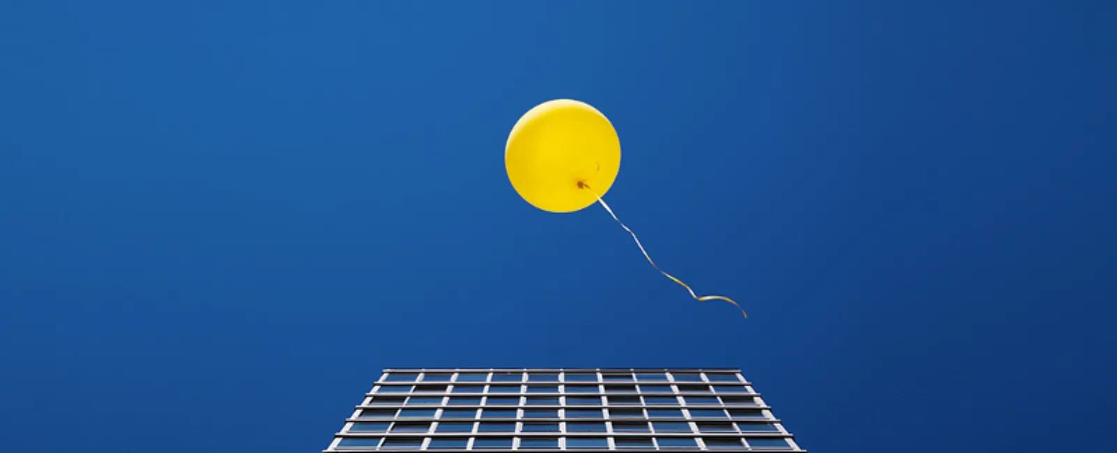 a yellow balloon floating over a solar panel