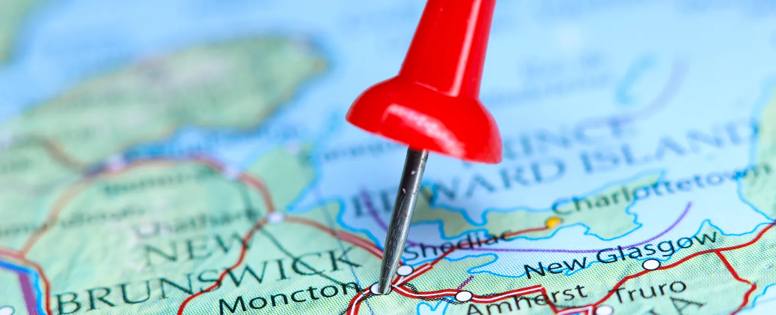 Red pushpin marking Moncton on a detailed map of New Brunswick and surrounding areas.