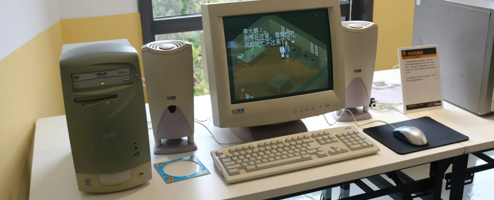 An out of date desktop computer setup with CRT monitor, tower, speakers, keyboard, and mouse on a white table