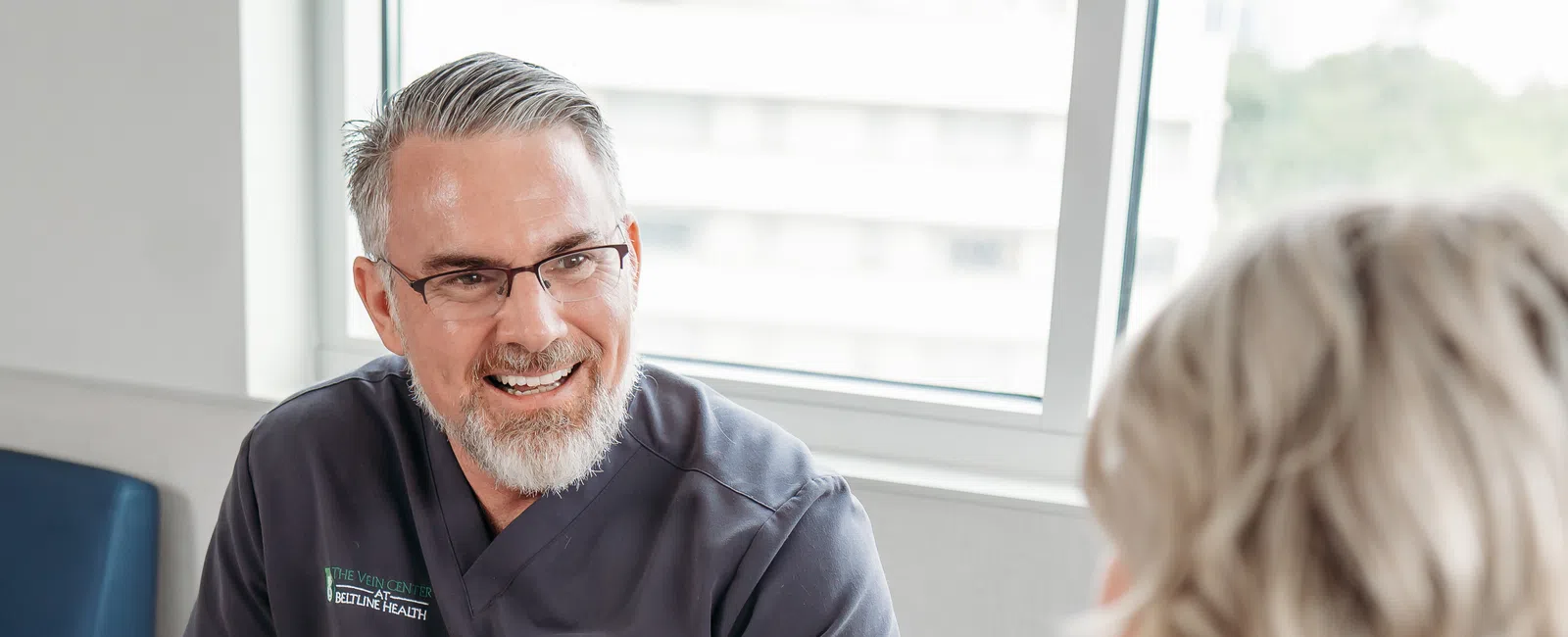 Vein specialist consulting with a patient about morning leg heaviness, a possible sign of chronic venous insufficiency, at Beltline Health.