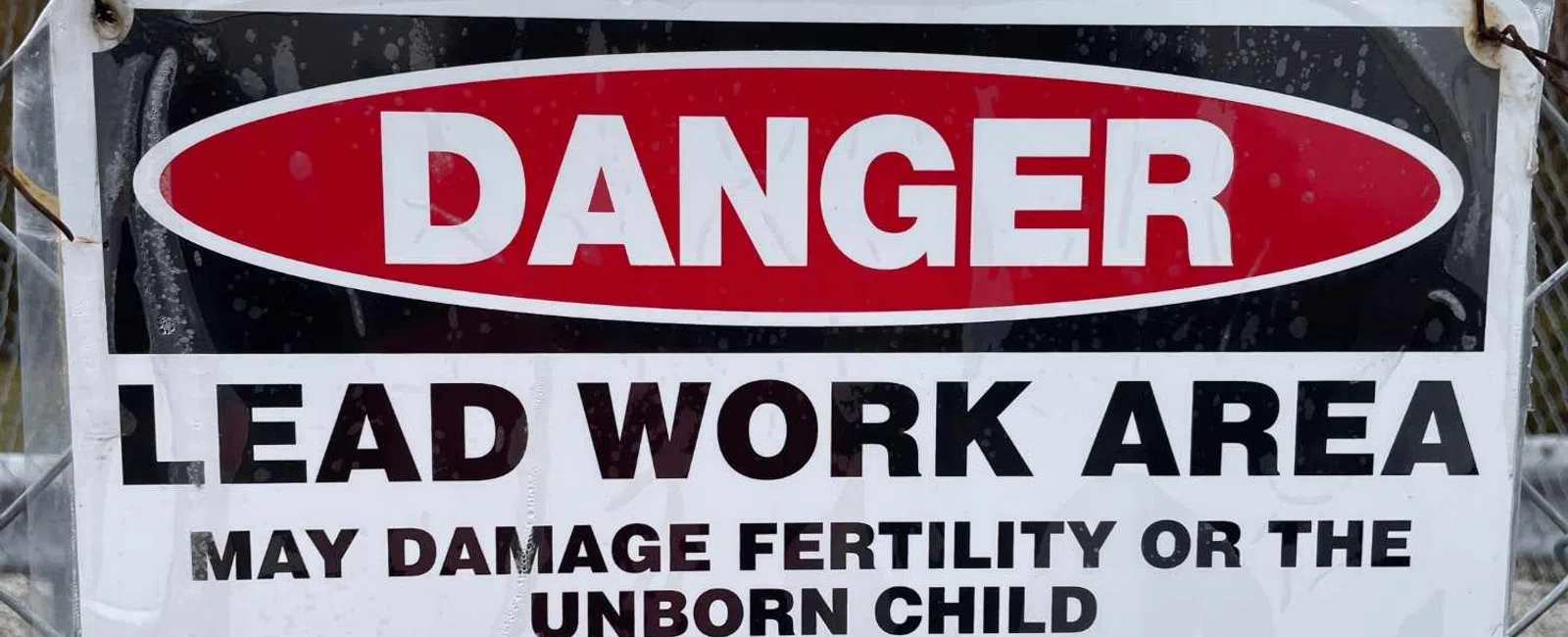 Danger sign warning of lead work area with health risks and instructions not to eat, drink, or smoke in the area.