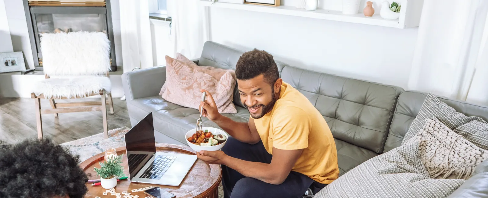 Happy family enjoying time together in cozy living room with laptop and meal on wooden coffee table