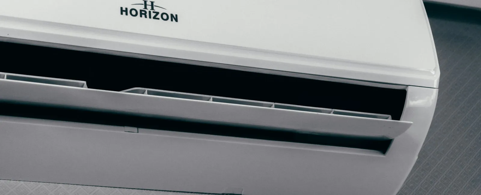 White Horizon wall-mounted air conditioner showing digital temperature display and open air vents.