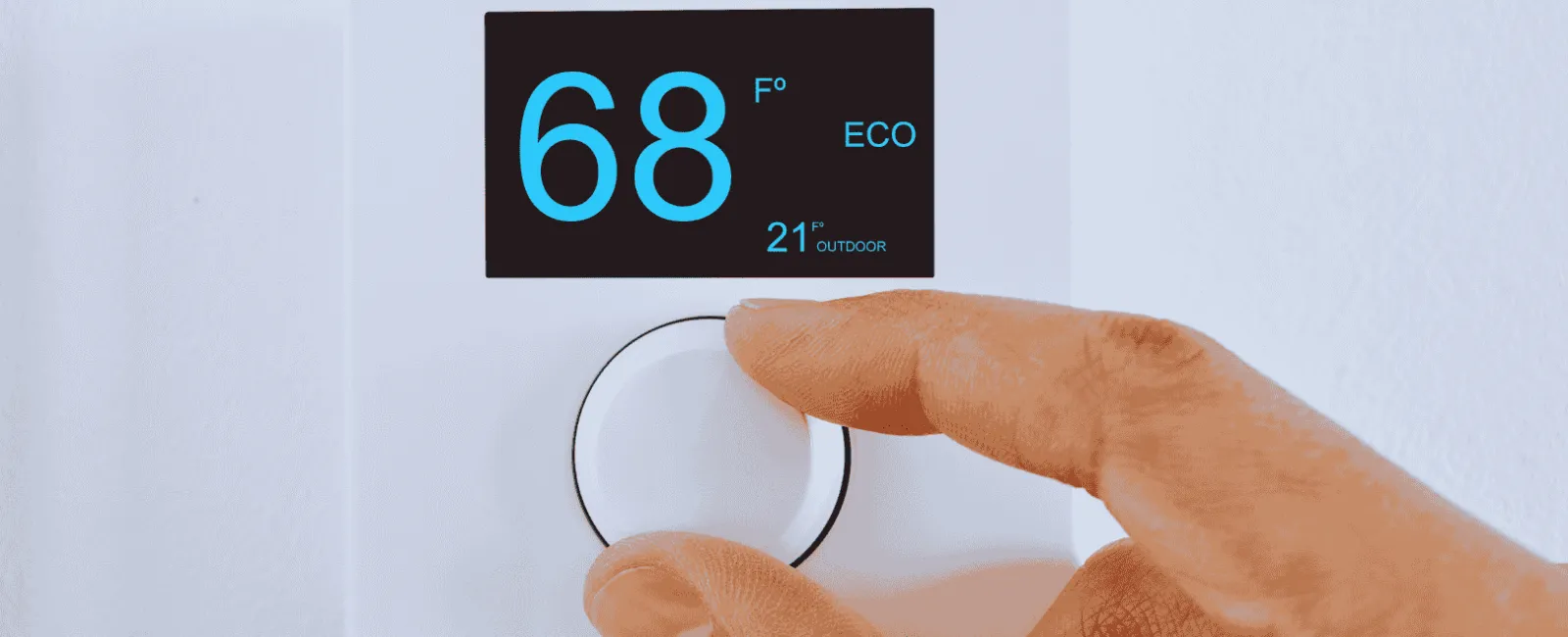 Hand adjusting a modern digital thermostat set at 68 degrees Fahrenheit in eco mode on a white wall.