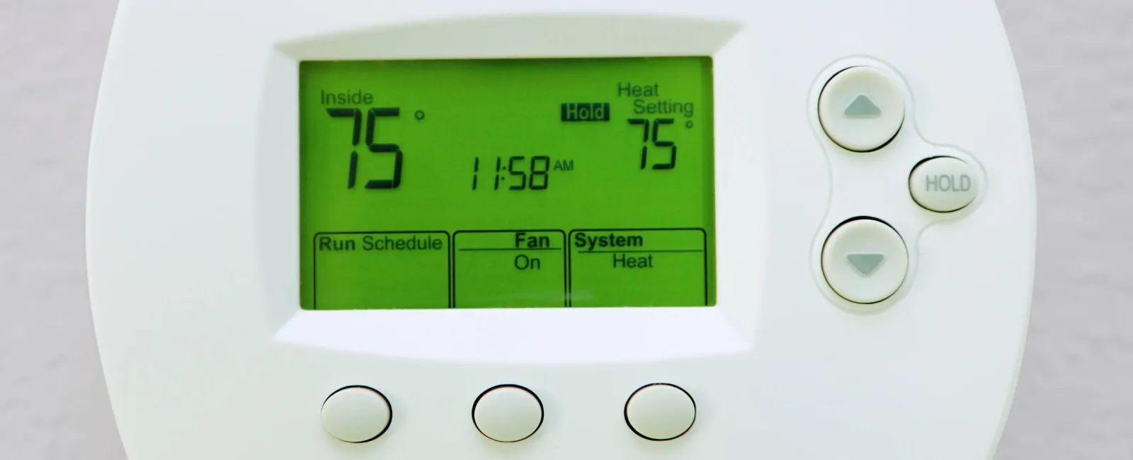 Digital thermostat showing inside temperature 75 degrees, heat setting 75 degrees, fan on, system heat.