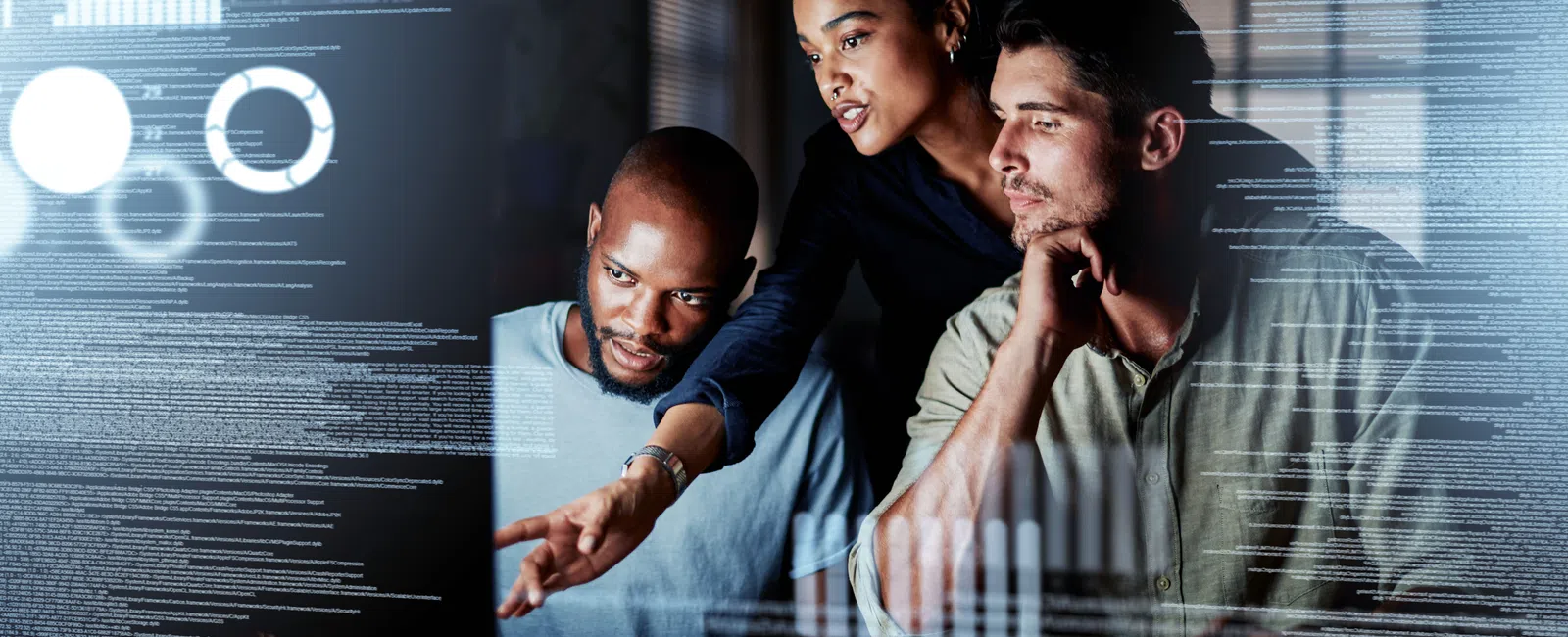 Three diverse professionals analyzing data charts and code on a transparent digital screen in a modern office.