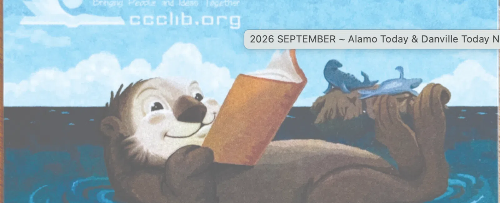 Illustration of a smiling sea otter reading a book while floating in water with seals on a nearby rock under a blue sky.